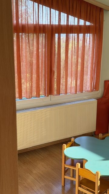 Γαλάζιο τραπεζάκι με ξύλινες καρέκλες δίπλα στο παράθυρο